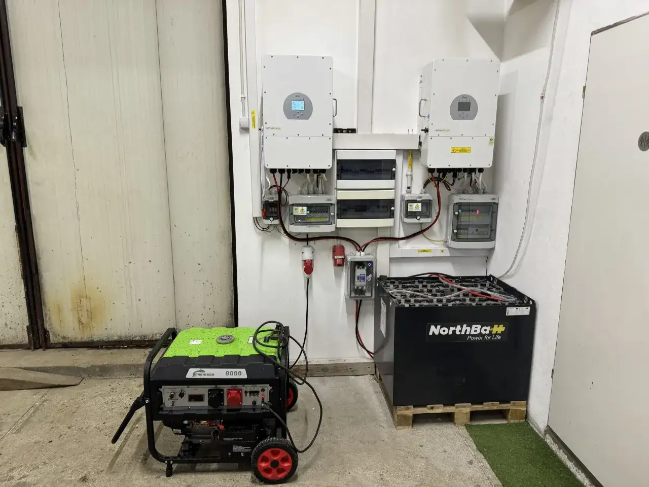 System magazynowania energii do fotowoltaiki: dwa falowniki, skrzynka z zabezpieczeniami, agregat prądotwórczy i duży magazyn energii NorthBaH.